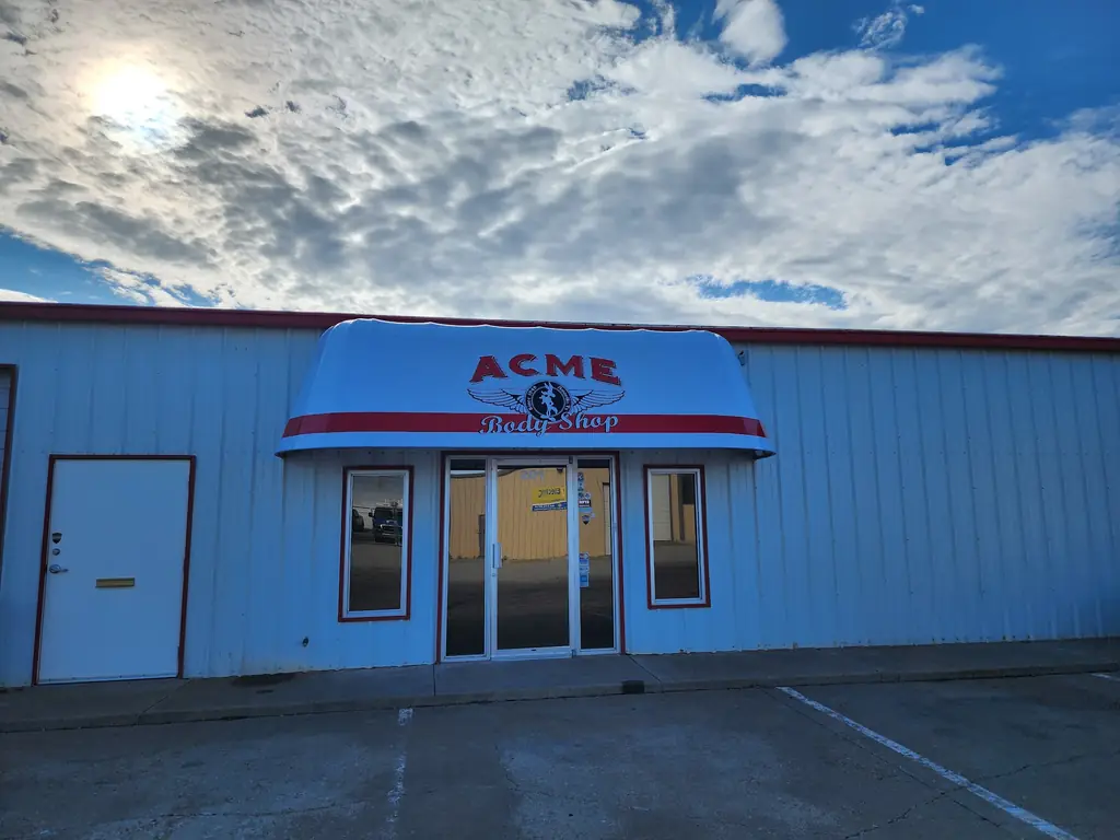 The Acme Body Shop storefront, red trim and the ACME awning over the door at 201 S Ong Street